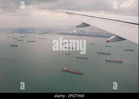 19.11.2019, Singapur, Republik Singapur, Asien - Luftaufnahme von einem Flugzeugfenster beim Anflug zum Flughafen Singapur Changi mit Schiffen unten. Stockfoto