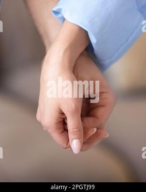 Die Hände des Paares berühren sich gegenseitig die Fingerspitzen und symbolisieren ihre tiefe emotionale Verbindung und die Bedeutung körperlicher Berührung für die Aufrechterhaltung der mentalen Er Stockfoto