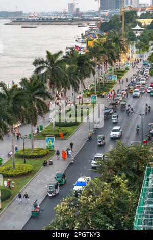 Viele kambodschanische Autos, Motorräder und Khmer Menschen bei Sonnenuntergang, geschäftigste Tageszeit. Sisowath Quay, eine beliebte Strip und Fußgängerzone, Leute und Familien CO Stockfoto