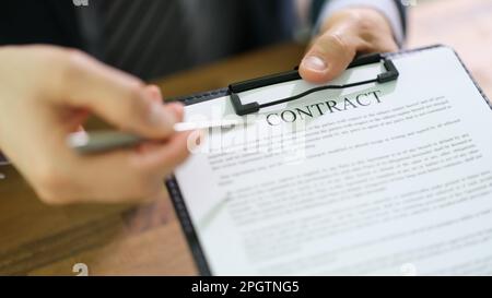 Manager, der den Dokumentvertrag auf der Zwischenablage und mit Stift zur Unterzeichnung des Abschlussberichts ablegt Stockfoto
