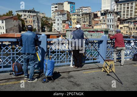 Fischer, die auf der Galata-Brücke angeln, wo das Goldene Horn auf die Straße des Bosporus, Karakoy, Beyoglu, Istanbul, Türkei/Turkiye trifft. Stockfoto