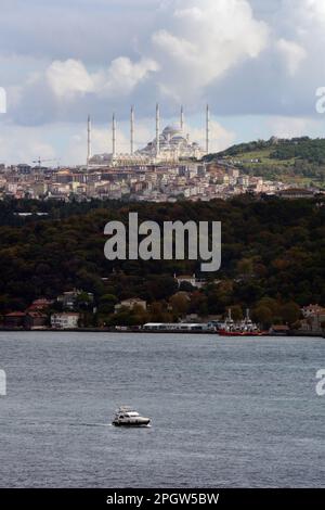 Ein Motorboot und eine Yacht, die über die Straße des Bosporus, in der Nähe des Viertels Uskudar, auf der asiatischen Seite von Istanbul, in der Türkei/Turkiye, fährt. Stockfoto