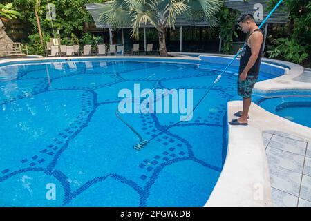 Tortuguero-Nationalpark, Costa Rica - Ein Mitarbeiter reinigt den Swimmingpool in der Evergreen Lodge, einem Hotel im Küstenregenwald. Stockfoto