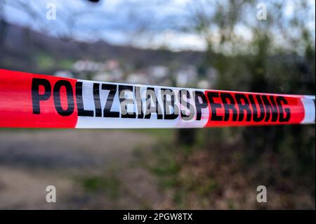 Deutsches Polizeiabsperrband, auf dem "Polizeiabsperrung" auf rotem und weißem Band steht Stockfoto