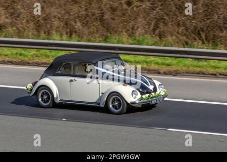 1972 70s, Siebzigerjahre Schwarzweiß VW VOLKSWAGEN Cabriolet restauriert Vee Dub Hochzeitswagen mit Linkslenkung, mit Blumen und Bändern geschmückt; Fahrt auf der Autobahn M61 UK Stockfoto