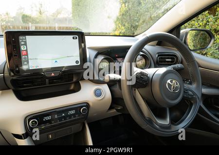 Innenansicht eines neuen, in Japan gebauten Hybrid-Kleinfahrzeugs. Zeigt den großen Touchscreen-Navigationsbildschirm und das elektronische Armaturenbrett. Stockfoto