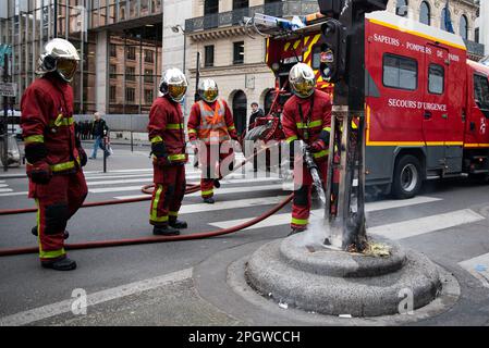 Feuerwehrleute in Paris löschen einen Brand, der von Demonstranten während eines Generalstreiks über die Erhöhung des Rentenalters ausgelöst wurde. Der neunte Streiktag gegen die neue Rentenreform von Macrons Regierung war von zahlreichen Zusammenstößen zwischen der Polizei und den Demonstranten geprägt. Nachdem Elisabeth Borne (Premierministerin Frankreichs) Artikel 49,3 der französischen Verfassung geltend gemacht hatte, um das neue Gesetz zu erzwingen, nahmen Tausende von Menschen bei einer Demonstration, die am Place de la Bastille begann, erneut die Straßen von Paris auf. (Foto: Ximena Borrazas/SOPA Images/Sipa USA) Stockfoto