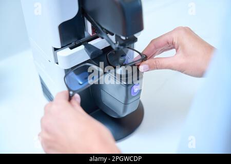 Der qualifizierte Optiker stellt in der modernen Klinik Optiker-Brillen her Stockfoto