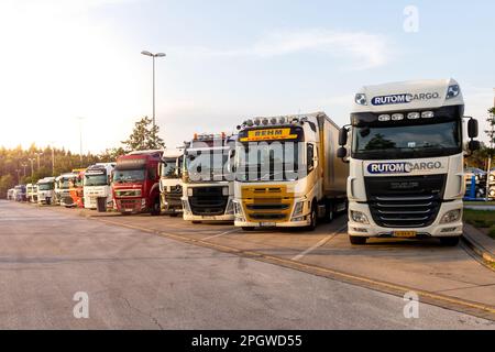 Reihe von verschiedenen Firmen-Lkw auf einem LKW-Parkplatz über Nacht somwehere entlang der Autobahn E30 geparkt. Deutschland - 14. Juni 2019 Stockfoto