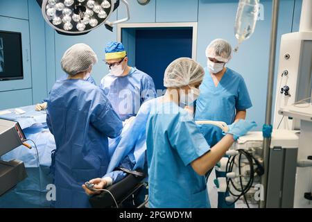 Das chirurgische Team führt eine Operation in einem sterilen Operationssaal durch Stockfoto