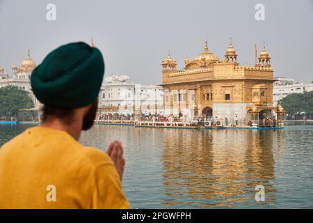 Amritsar, Punjab, Indien - Diwali 2019 - junger Sikh Mann, der vor dem Weihwasser des goldenen Tempels betet Stockfoto