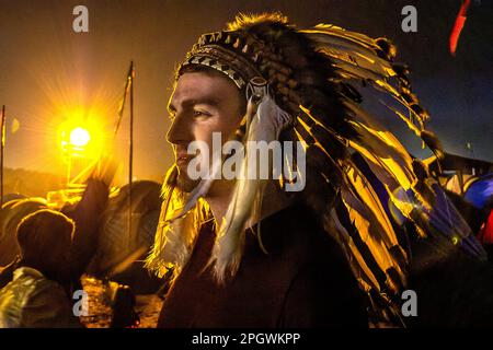 Glastonbury, Juni 26. 2014: In der Menge auf der Pyramide - Mann trägt einen jetzt verbotenen indianischen Kopfschmuck Stockfoto