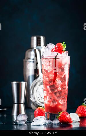 Oldboy alkoholisches Cocktailgetränk mit Wodka, Grapefruitsaft, Erdbeeren, Zucker, Zimt und heißem Chili-Pfeffer. Highball-Glas auf dunkelblauem Hintergrund Stockfoto