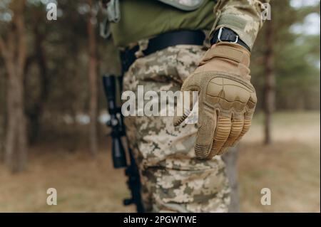 Militärhand. Taktische Tarnhandschuhe. Stockfoto