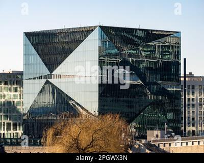 Bürogebäude Cube Berlin mit einzigartiger Architektur. Die Glasfassade reflektiert das Licht und erzeugt interessante visuelle Effekte. Modernes Haus Stockfoto