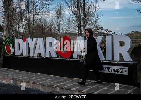 Diyarbakir, Türkei. 22. März 2023. Eine Frau posiert für ein Foto vor dem Diyarbakir-Schild auf der Brücke. Die Tigris Bridge, allgemein bekannt als die Brücke mit zehn Augen, ist eine der ältesten Brücken, die über dem Tigris River gebaut wurde. Es ist bekannt, dass die Brücke 1065 von den Marwaniden gebaut wurde. (Kreditbild: © Murat Kocabas/SOPA Images via ZUMA Press Wire) NUR REDAKTIONELLE VERWENDUNG! Nicht für den kommerziellen GEBRAUCH! Stockfoto