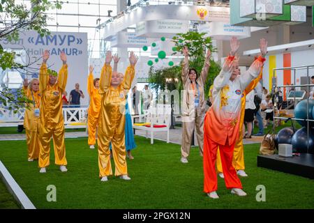 Eine Gruppe von Menschen, die gemeinsam Qigong-Übungen auf der Ausstellung machen Stockfoto