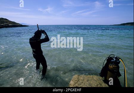 . Ein Taucher, der sich auf einen Tauchgang vom Strand vorbereitet. Alghero. Sardinien. Italien Stockfoto
