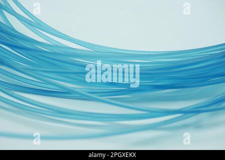 Abstrakter Hintergrund, geschaffen durch eine blaue Nylonfischleine auf einem weißen Hintergrund Stockfoto