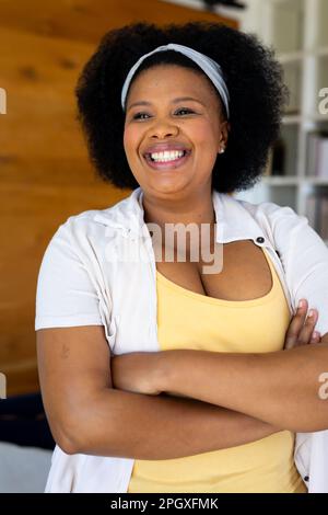 Eine glückliche afroamerikanerin in Übergröße, die wegsieht und lächelt Stockfoto