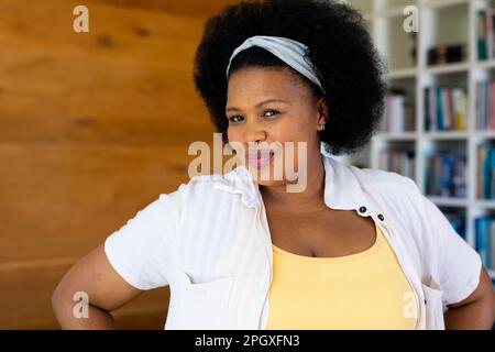 Porträt einer glücklichen afroamerikanischen Frau in Übergröße, die in die Kamera schaut und lächelt Stockfoto
