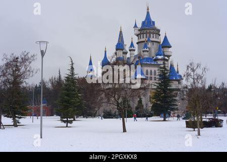 Nostalgische alte Burg im Sazova Park Eskisehir mit blauen Türmen. Unter Schnee an einem kalten Wintertag mit Bäumen und Büschen unter Schnee. Stockfoto