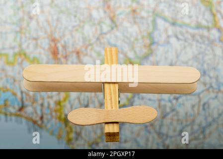 Avión de madera hecho con palos de helado y una pinza de la ropa, volando sobre un Mapa Stockfoto