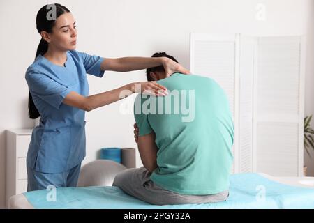 Der Orthopäden untersucht den Menschenhals in der Klinik. Skoliosebehandlung Stockfoto