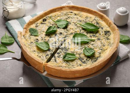 Frischer, köstlicher hausgemachter Spinatkuchen auf grauem Tisch Stockfoto