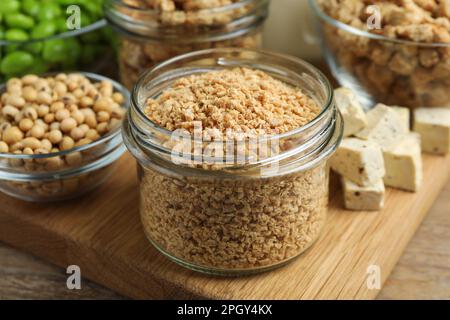 Dehydriertes Sojamleisch und andere Produkte auf Holztisch, Nahaufnahme Stockfoto