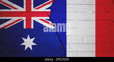 Gerissene Betonblockwand mit einer australischen Flagge auf der linken Seite und einer französischen Flagge auf der rechten Seite. Stockfoto