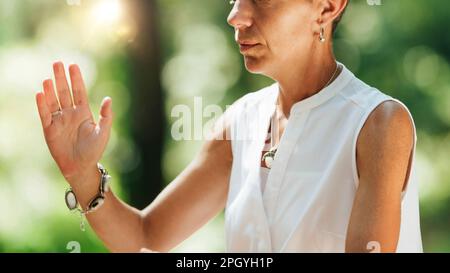 Frau, die Qigong im Wald praktiziert Stockfoto