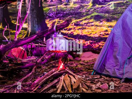 Teekessel auf offenem künstlichem Feuer. Tee im Camping Stockfoto