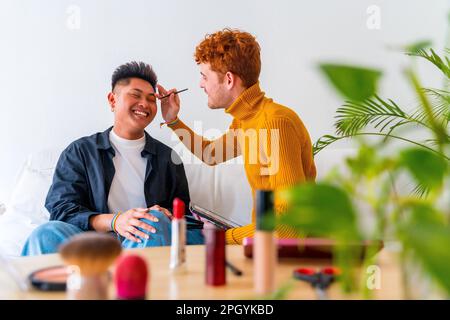 Wunderschönes schwules Paar, das sich schminkt und Spaß hat, zu Hause romantisch zu sein, lgbt-Konzept Stockfoto