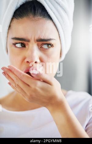 Kommt dieser Geruch von mir? Eine wunderschöne junge Frau, die zu Hause den Atem kontrolliert. Stockfoto