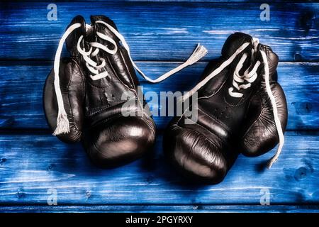 Boxhandschuhe auf blauem Holzhintergrund Stockfoto