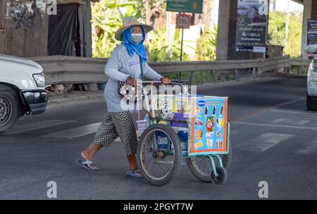 BANGKOK, THAILAND, JANUAR 28 2023, ein Eisverkäufer schiebt einen Wagen über die Straße an einer Kreuzung Stockfoto