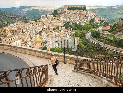 Luftaufnahme von Ragusa Sizilien mit einer Frau, die im Vordergrund Treppen hinuntergeht Stockfoto