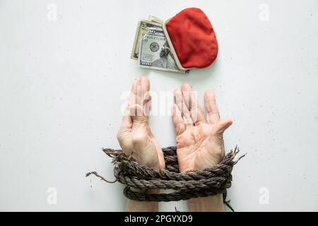 Rote Brieftasche mit amerikanischen Dollar aus den Händen einer Frau, gefesselt auf weißem Hintergrund Stockfoto