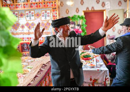 (230325) -- TAXKORGAN, 25. März 2023 (Xinhua) -- Duri Jarman feiert das Noruz-Festival in seinem Haus in Aimin, Dorf Taxkorgan Tajik Autonomous County, Nordwest-Chinas Autonome Region Xinjiang Uygur, 21. März 2023. Das Leben des Hirten Duri Jarman ist eng mit zwei Orten verbunden: Dem Dorf AK Toga Langar, eingebettet tief in die Berge des Taxkorgan Tajik Autonomous County, und dem Dorf Aimin, das sich in der Nähe des Bezirkssitzes befindet. Duri, jetzt 52 Jahre alt, lebte 47 Jahre im Dorf AK Toga Langar. Im Winter 2018 profitierte seine Familie von der Umsiedlungspolitik für Stockfoto