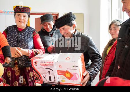(230325) -- TAXKORGAN, 25. März 2023 (Xinhua) -- Nachbarn bieten ihren Segen an, da Duri Jarman in sein neues Zuhause in Aimin Dorf Taxkorgan Tajik Autonomous County, Nordwestchina Xinjiang Uygur Autonomous Region umzieht, 18. November 2018. Das Leben des Hirten Duri Jarman ist eng mit zwei Orten verbunden: Dem Dorf AK Toga Langar, eingebettet tief in die Berge des Taxkorgan Tajik Autonomous County, und dem Dorf Aimin, das sich in der Nähe des Bezirkssitzes befindet. Duri, jetzt 52 Jahre alt, lebte 47 Jahre im Dorf AK Toga Langar. Im Winter 2018 profitierte seine Familie von der Umsiedlung Stockfoto