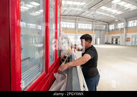 (230325) -- TAXKORGAN, 25. März 2023 (Xinhua) -- Duri Jarman überprüft einen Kühlschrank, den er für seinen Laden im Dorf Aimin in Taxkorgan Tajik Autonomous County, Nordwestchina Xinjiang Uygur Autonomous Region, 24. Juni 2020 gekauft hat. Das Leben des Hirten Duri Jarman ist eng mit zwei Orten verbunden: Dem Dorf AK Toga Langar, eingebettet tief in die Berge des Taxkorgan Tajik Autonomous County, und dem Dorf Aimin, das sich in der Nähe des Bezirkssitzes befindet. Duri, jetzt 52 Jahre alt, lebte 47 Jahre im Dorf AK Toga Langar. Im Winter 2018 profitierte seine Familie von der Umsiedlungspolitik für Po Stockfoto