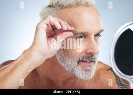 Seniorenmann, Pinzette und Spiegel im Bad, überprüfen in einem Studio, das Haare entfernt und pflegt. Wellness, Augenbrauen und Schönheitsroutine einer männlichen Modellbetreuung Stockfoto