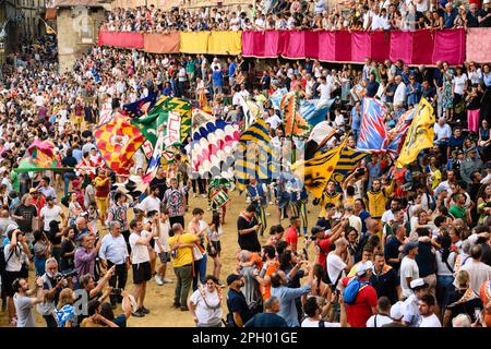 Siena, Italien - August 17 2022: Fahne schwenkt nach dem Palio di Siena mit Standardträgern der Contrada-Distrikte auf der Piazza del Camp Stockfoto