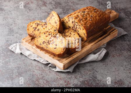Ein Stück Kürbisbrot mit Schokoladenchips auf dem Holzbrett auf dem Tisch. Horizontal Stockfoto