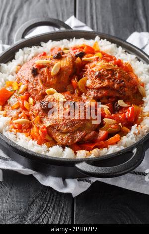 Country Captain ist ein Currygericht mit Hühnchen und Reis, das im Süden der USA beliebt ist, wenn man auf dem Tisch sitzt. Vertikal Stockfoto