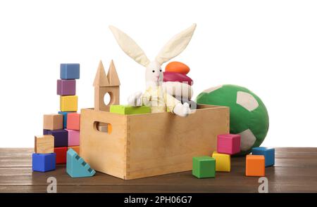 Set verschiedener Spielzeuge auf einem Holztisch vor weißem Hintergrund Stockfoto
