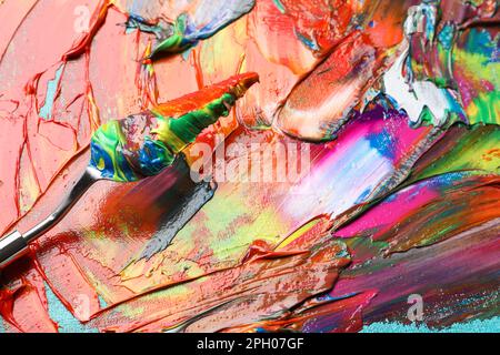 Bunte Acrylfarben und Malmesser auf Leinwand, Nahaufnahme Stockfoto