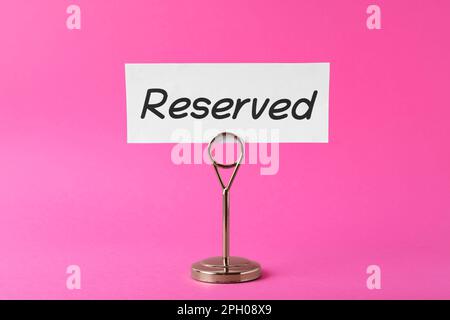 Elegantes Schild reserviert auf pinkfarbenem Hintergrund. Element für Tabelleneinstellung Stockfoto