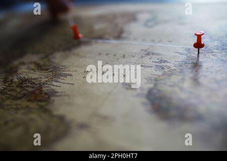 Reisekonzept. Karte und Nadel mit einer markierten Stelle. Kompasspunkt auf Karte und Routen. Stockfoto